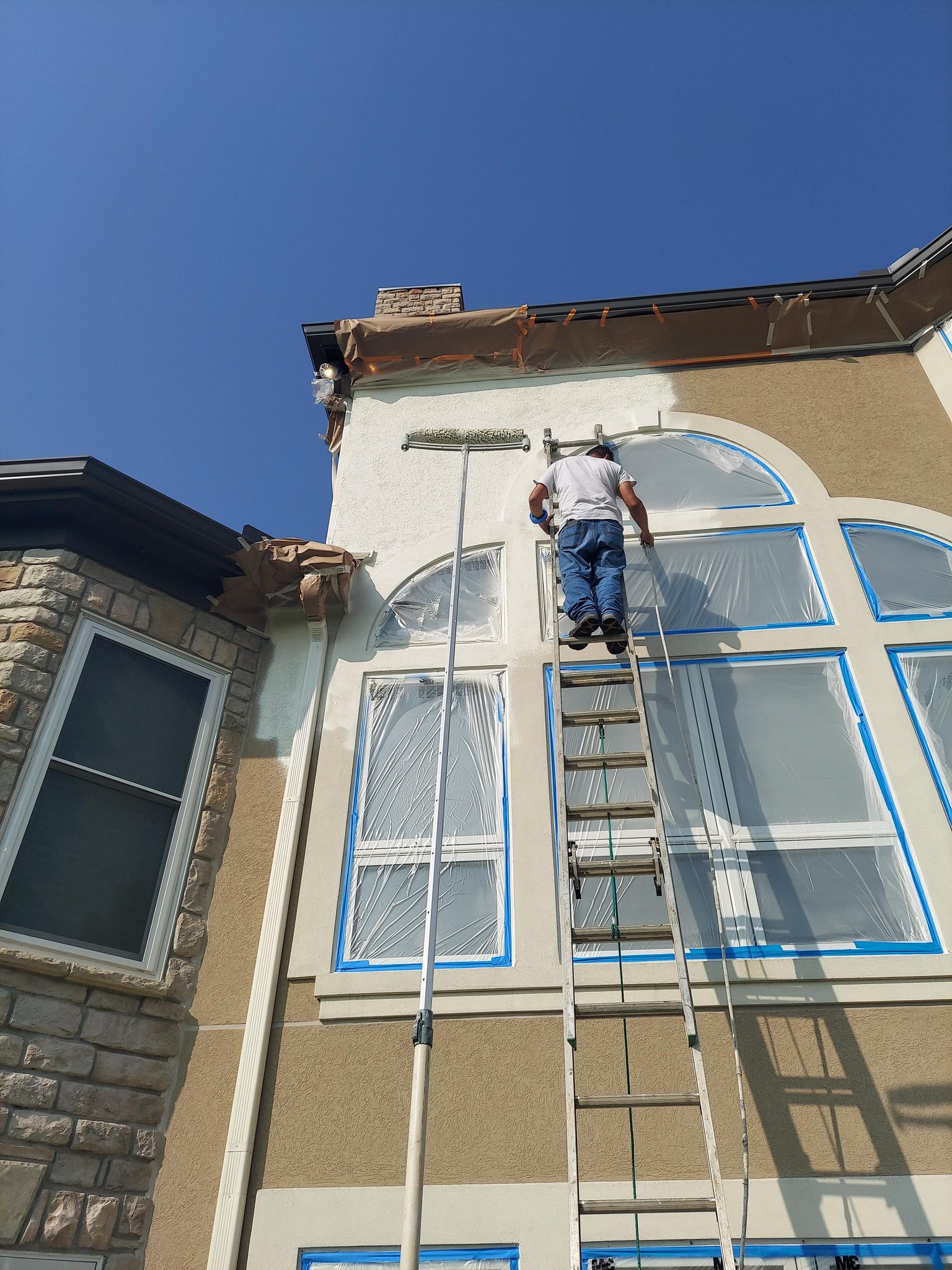 House Painter Painting Building Exterior With Roller